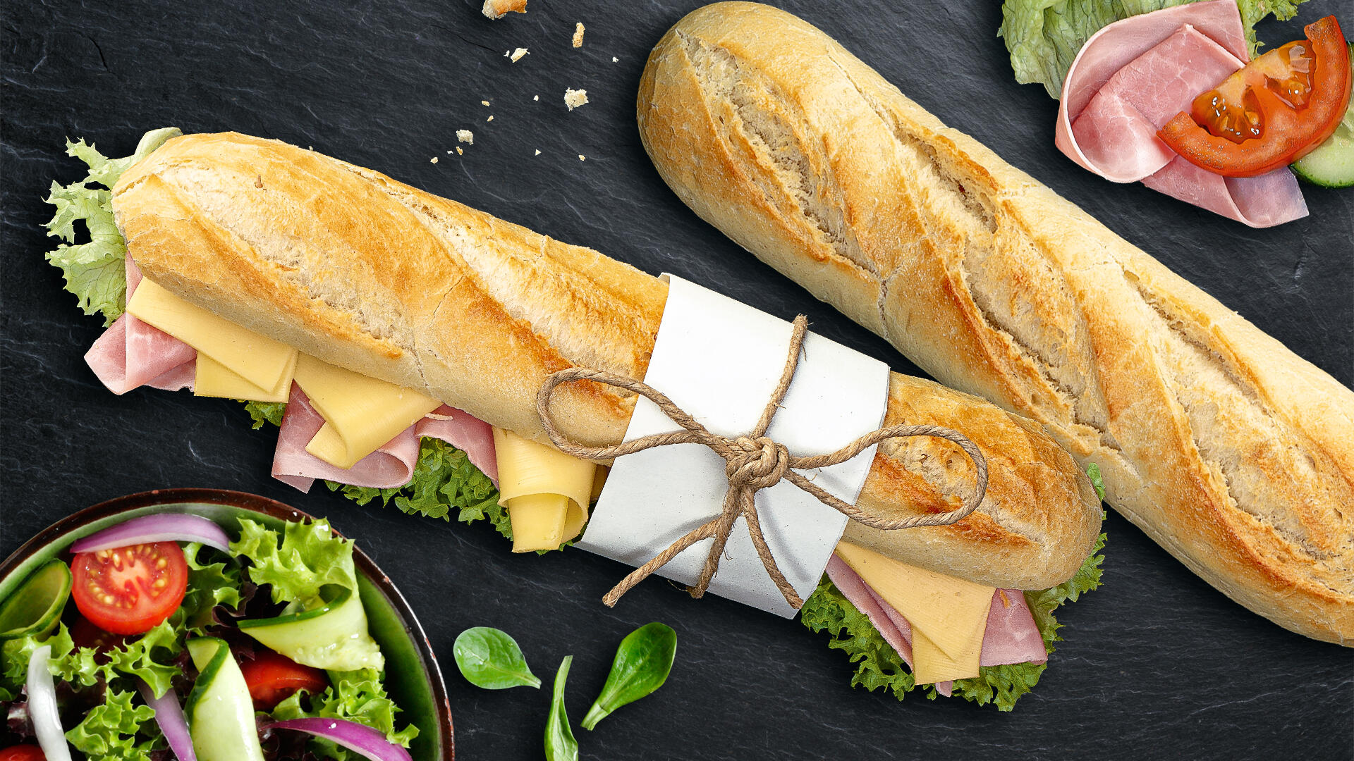 2 Baguettes eins belegt mit Käse und Schinken und das andere unbelegt
