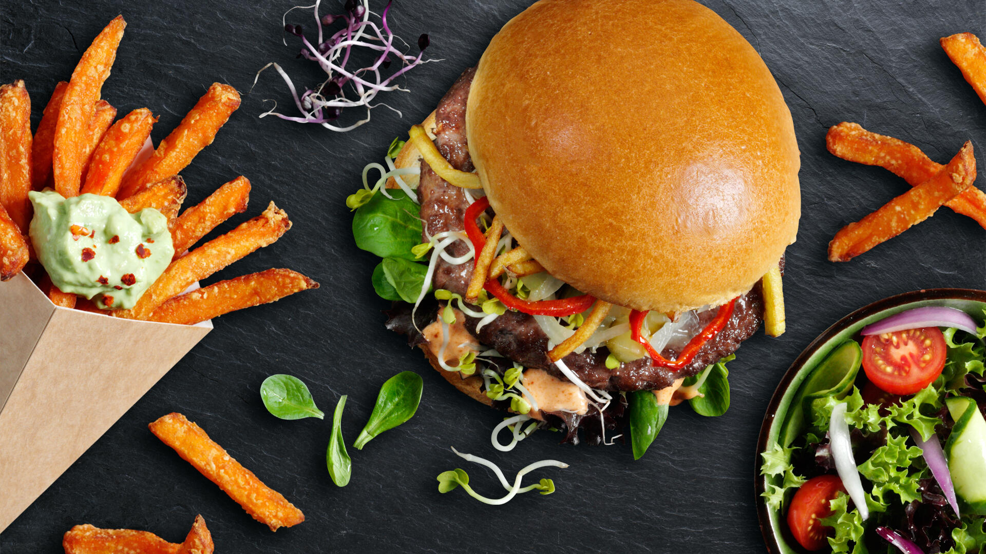 Belegter Brioche Burger mit Süßkartoffelpommes und Guacamole